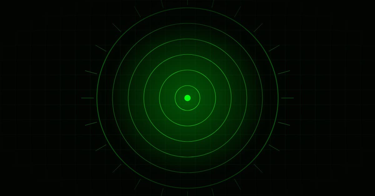 Cerchi concentrici stilizzati che si espandono da un nucleo, verde su nero